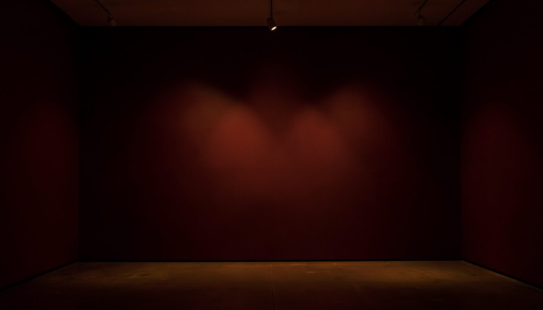 A dimly lit gallery interior with warm amber and deep burgundy tones, soft spotlight pools on an empty wall, evoking quiet anticipation.